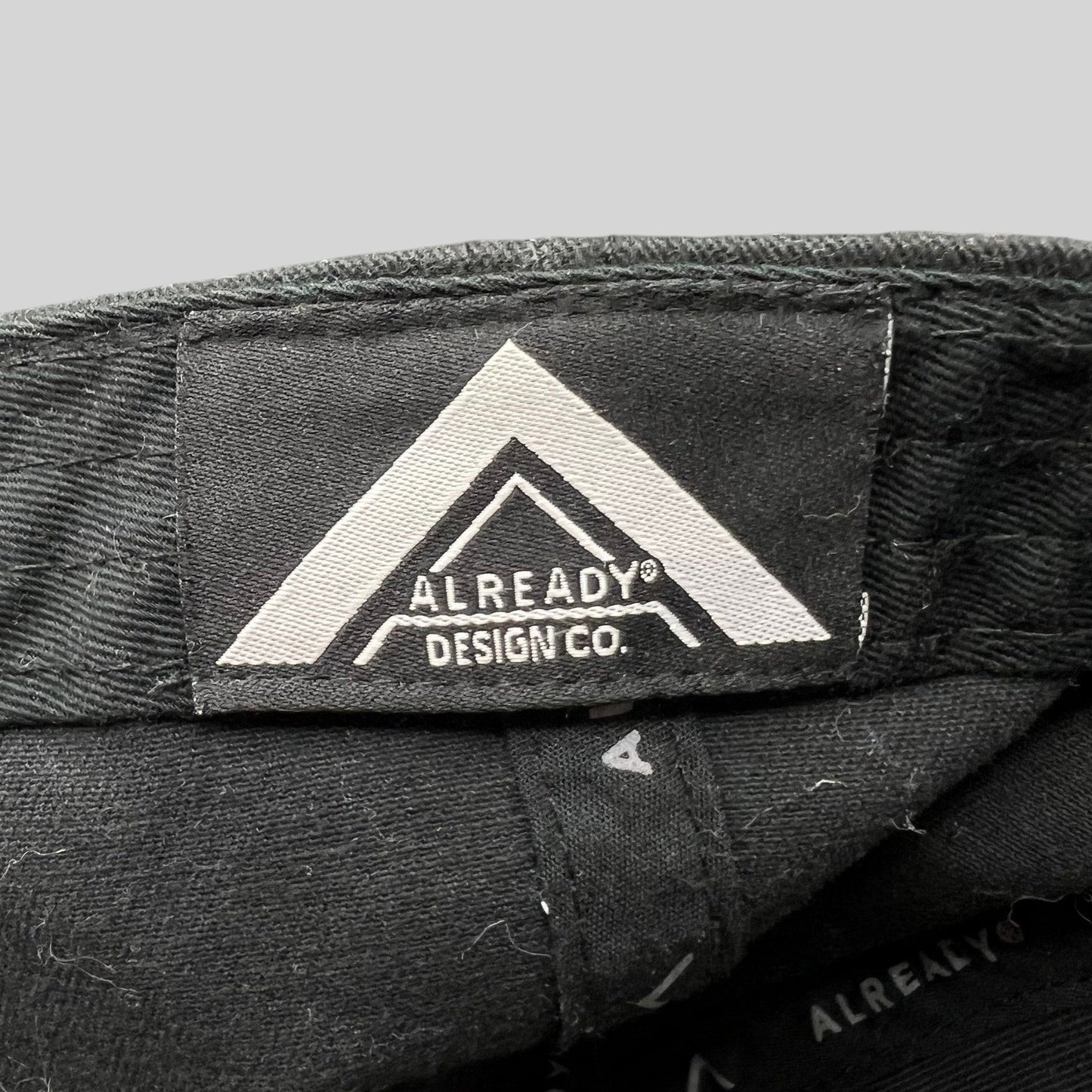 Raree Finds black strapback hat interior label featuring the Already Design Co. logo on a cotton blend fabric.