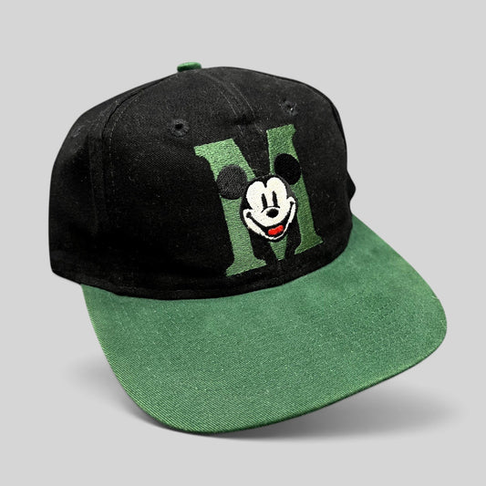 Raree Finds vintage 90s Disney Store Mickey Mouse snapback hat with a black crown and green embroidered M logo brim.