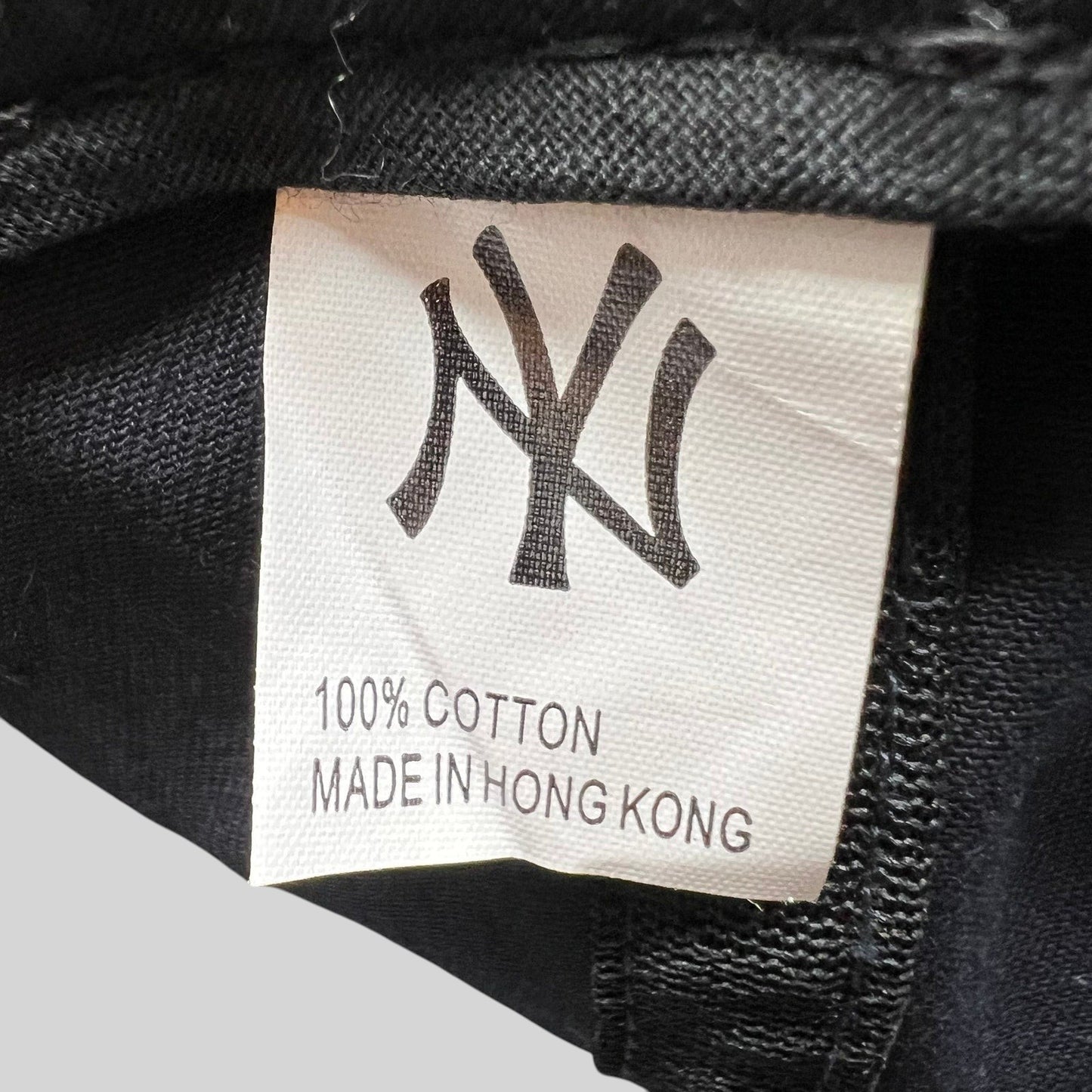 Raree Finds vintage New York Yankees hat interior tag showing 100% cotton material and Made in Hong Kong label