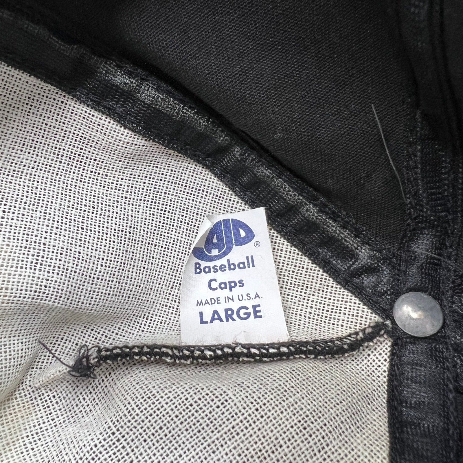 Raree Finds vintage AJD Baseball Caps tag inside a black snapback hat made in the USA