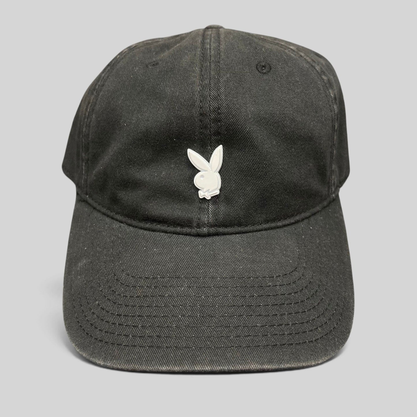 Raree Finds black strapback hat featuring a minimalist silver metal Playboy bunny logo on the front crown.