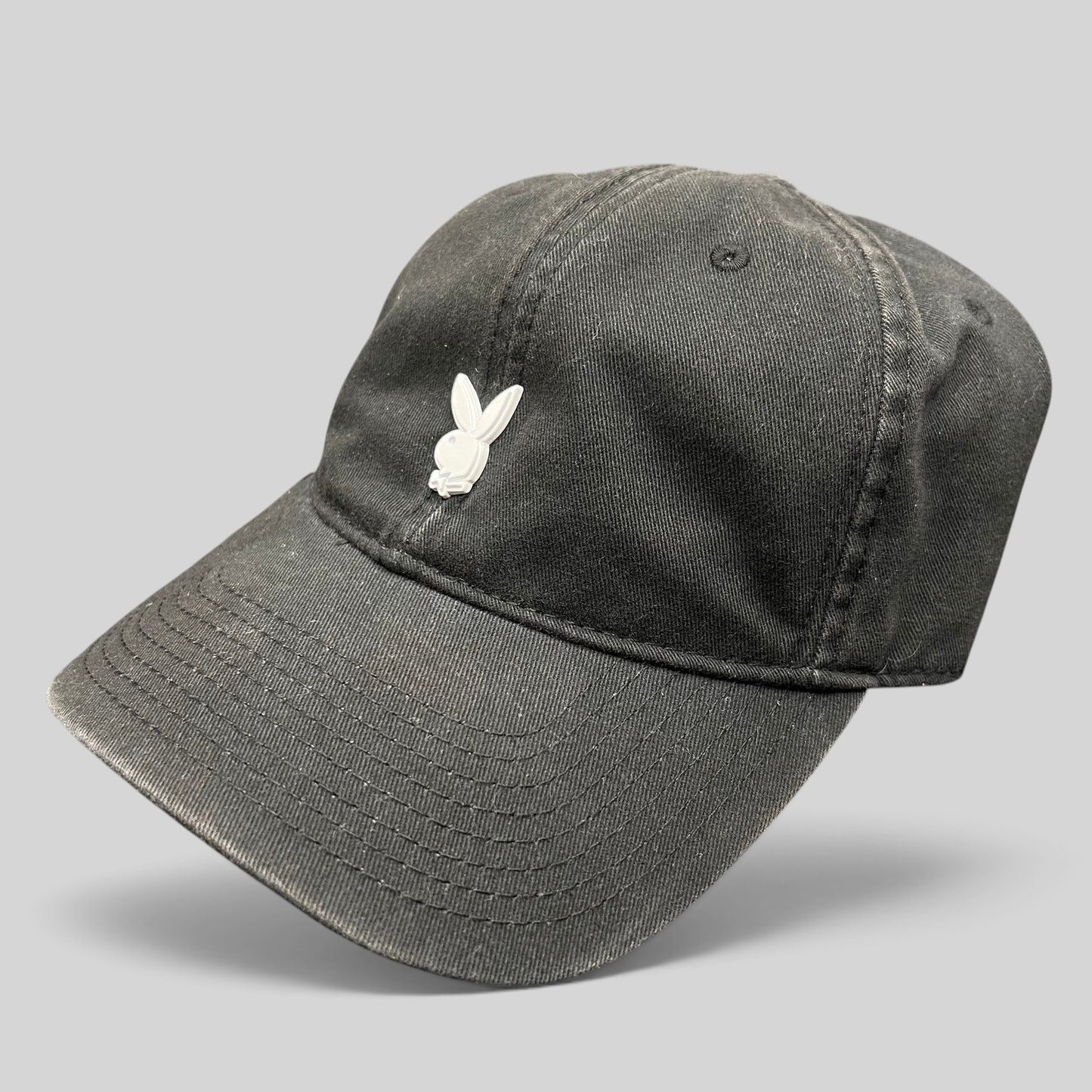 Raree Finds black cotton strapback hat featuring a minimalist raised metal Playboy bunny logo on the front crown.
