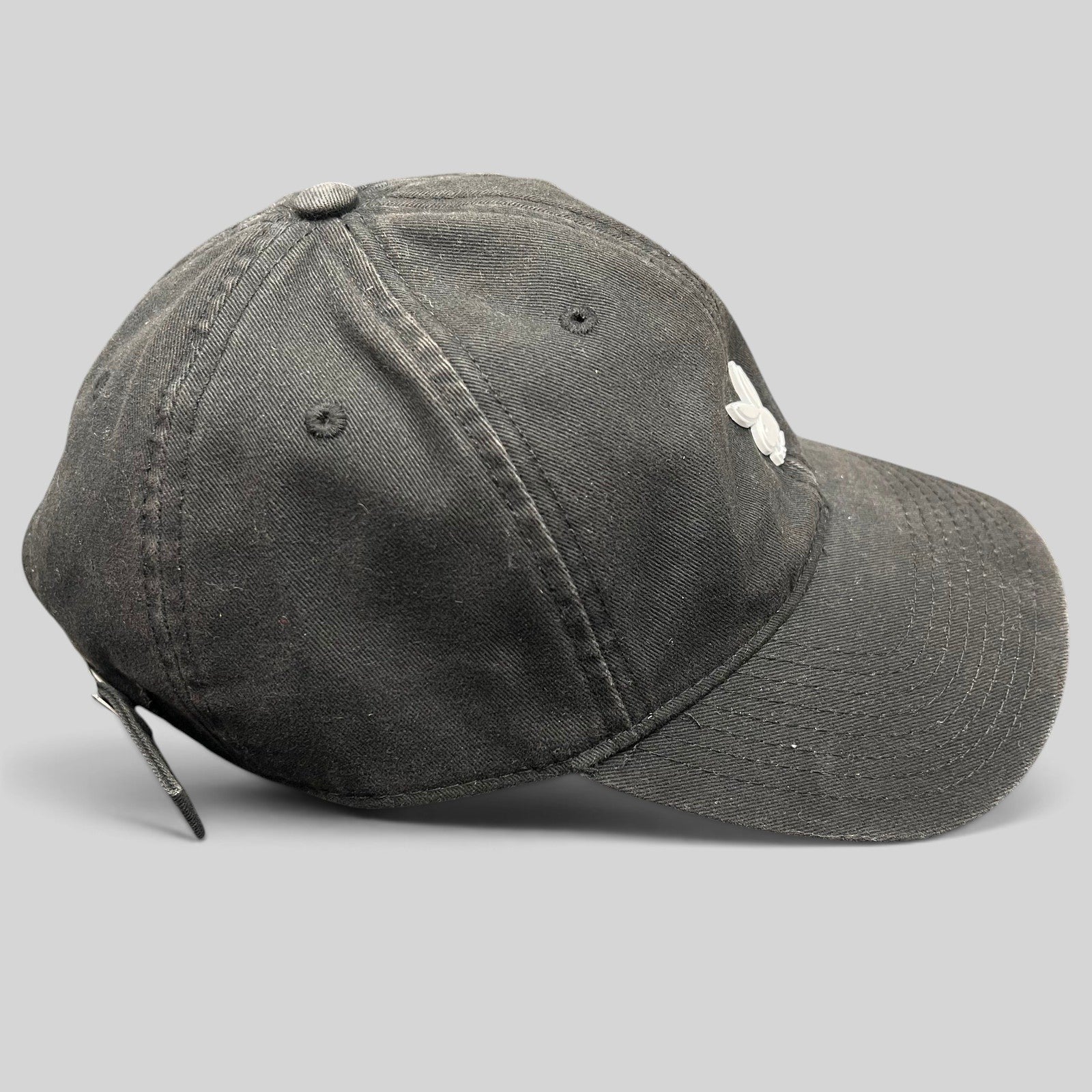 Raree Finds black cotton strapback hat with a minimalist metal Playboy bunny logo on the front crown