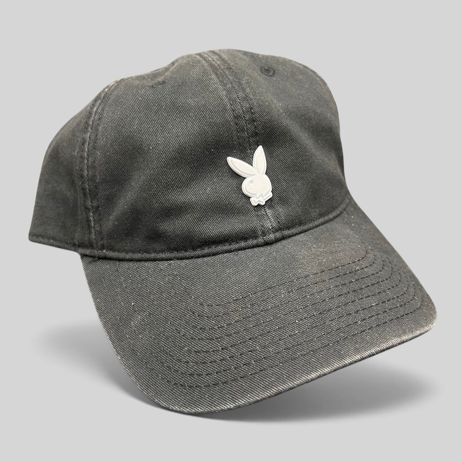 Raree Finds black cotton strapback hat featuring a minimalist silver metal Playboy bunny logo on the front crown
