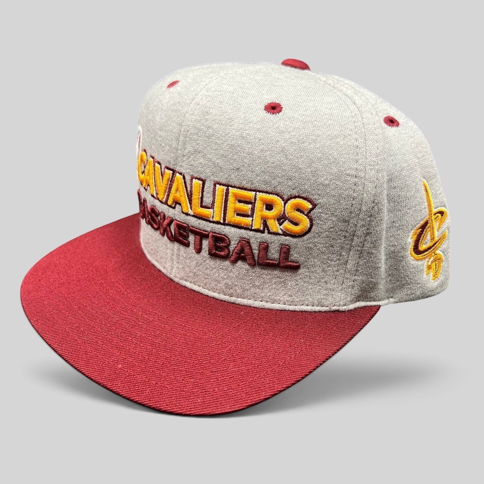Raree Finds Mitchell & Ness Cleveland Cavaliers snapback hat in heather gray with a wine red brim and gold embroidery.