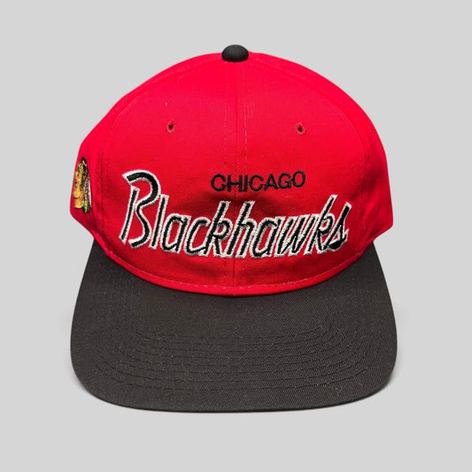 Raree Finds vintage 90s Chicago Blackhawks snapback hat with red crown, black brim, and silver script embroidery.