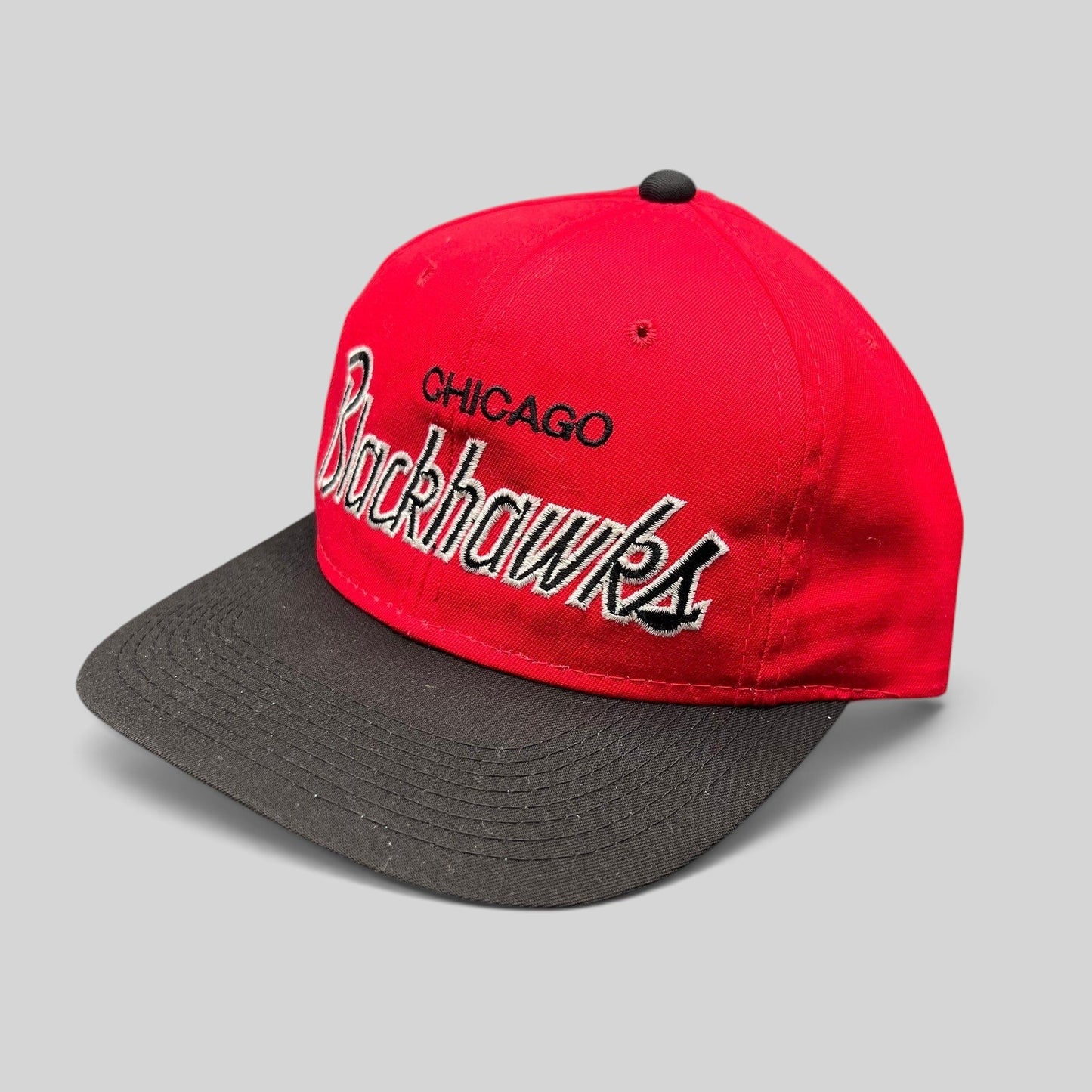 Raree Finds vintage 90s Chicago Blackhawks snapback hat with red crown, black brim, and silver script embroidery.