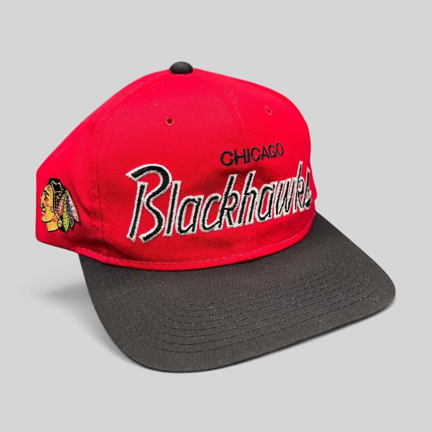 Raree Finds vintage 90s Chicago Blackhawks snapback hat with red crown, black brim, and silver script embroidery.