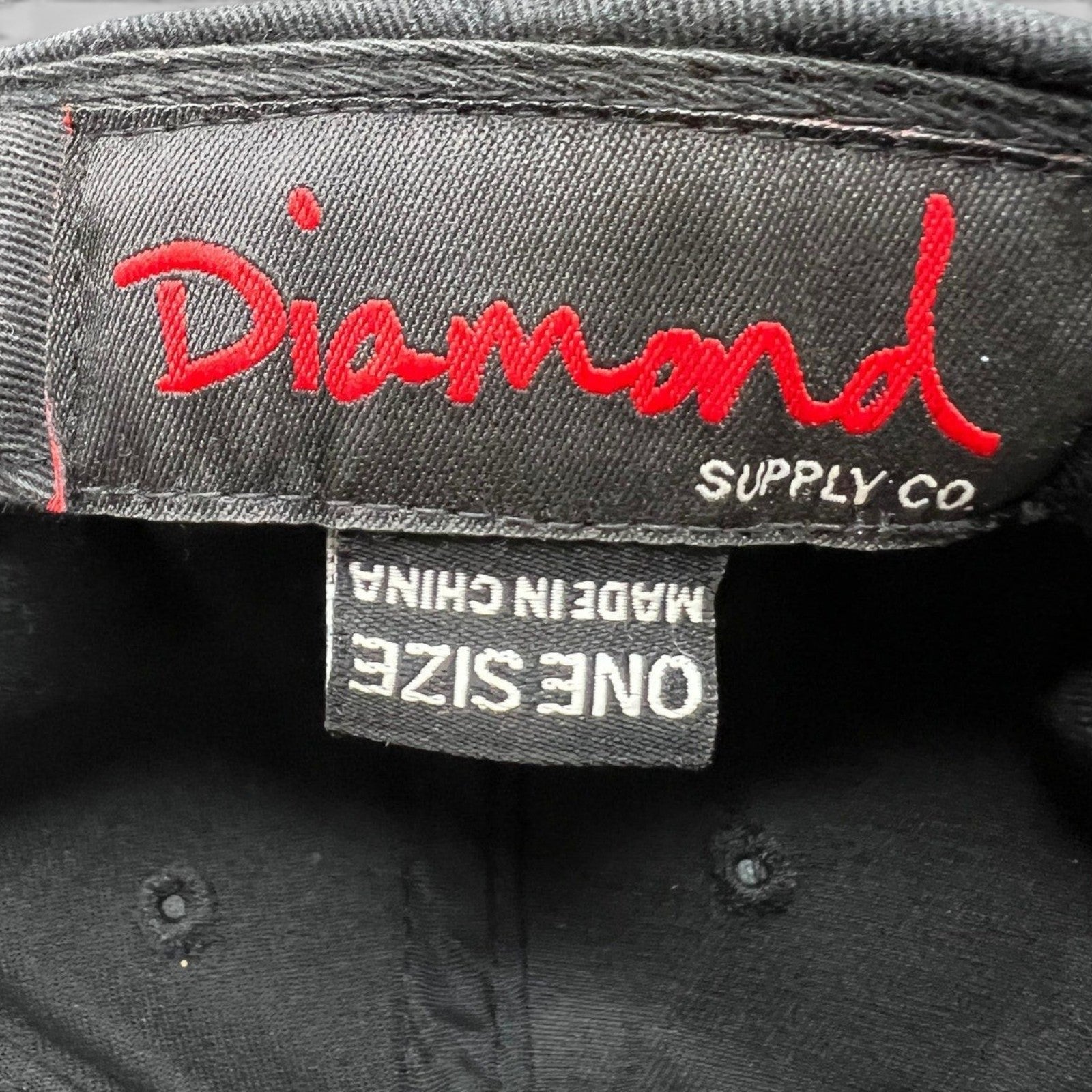 Raree Finds vintage Diamond Supply Co. snapback hat interior tag with red logo embroidery on black cotton fabric