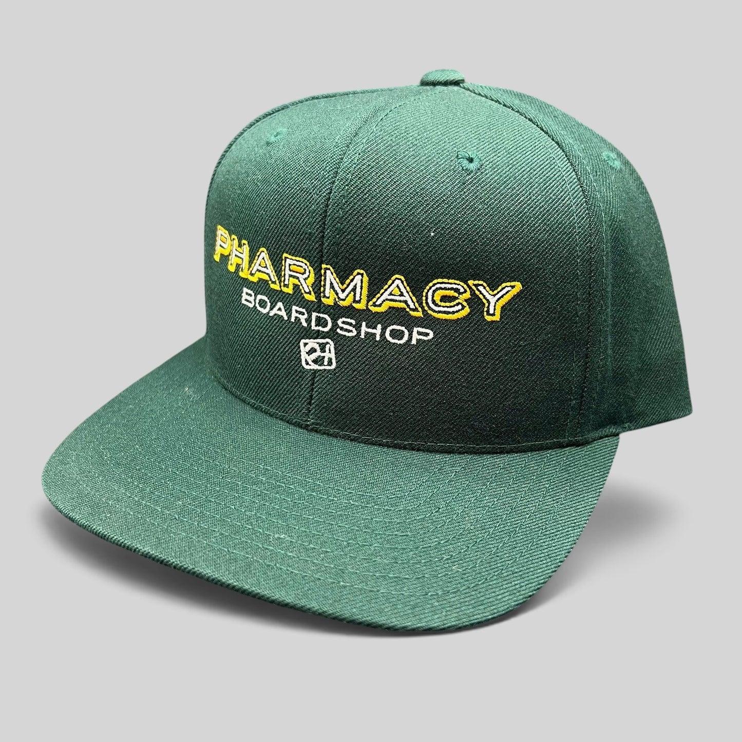 Raree Finds vintage forest green Pharmacy Boardshop snapback hat with yellow and white embroidered skate branding.