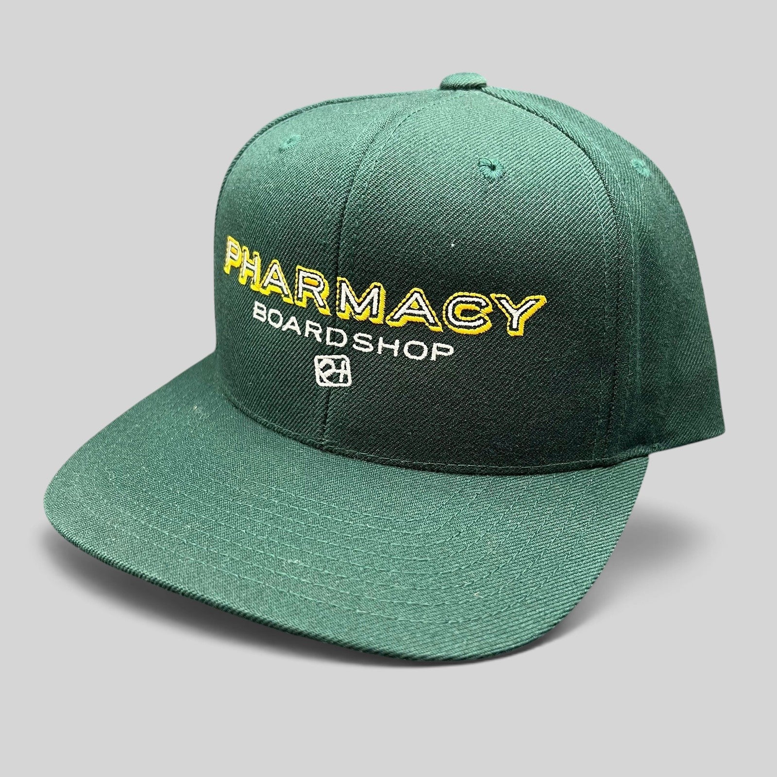 Raree Finds vintage forest green Pharmacy Boardshop snapback hat with yellow and white embroidered skate branding.