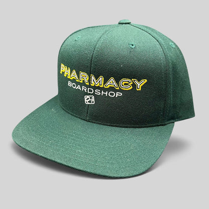 Raree Finds vintage forest green Pharmacy Boardshop snapback hat with yellow and white embroidered skate branding.