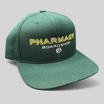 Raree Finds vintage forest green Pharmacy Boardshop snapback hat with yellow and white embroidery on a flat bill cap.