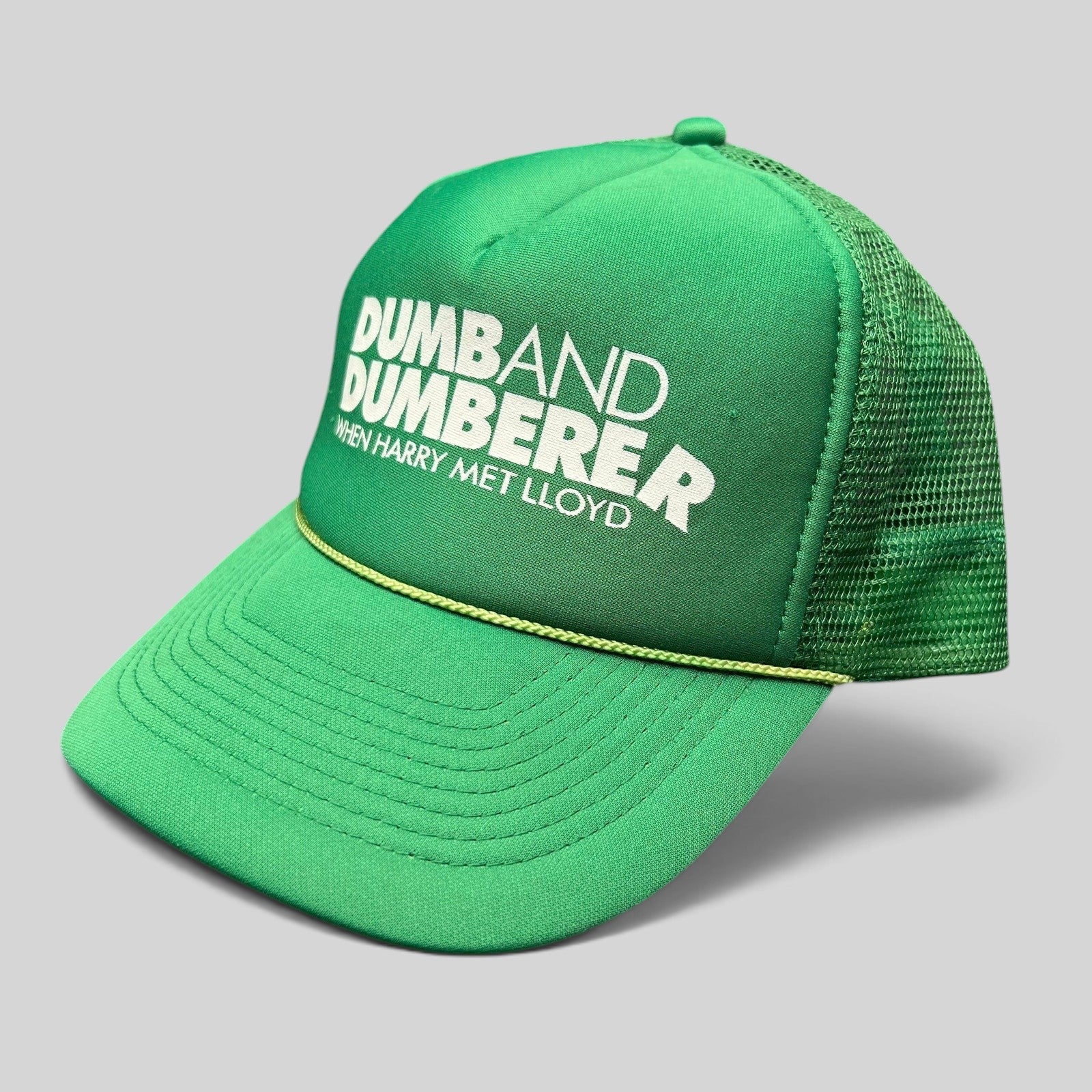 Raree Finds vintage green foam trucker hat with Dumb and Dumberer movie promo print and rope detail on the brim.