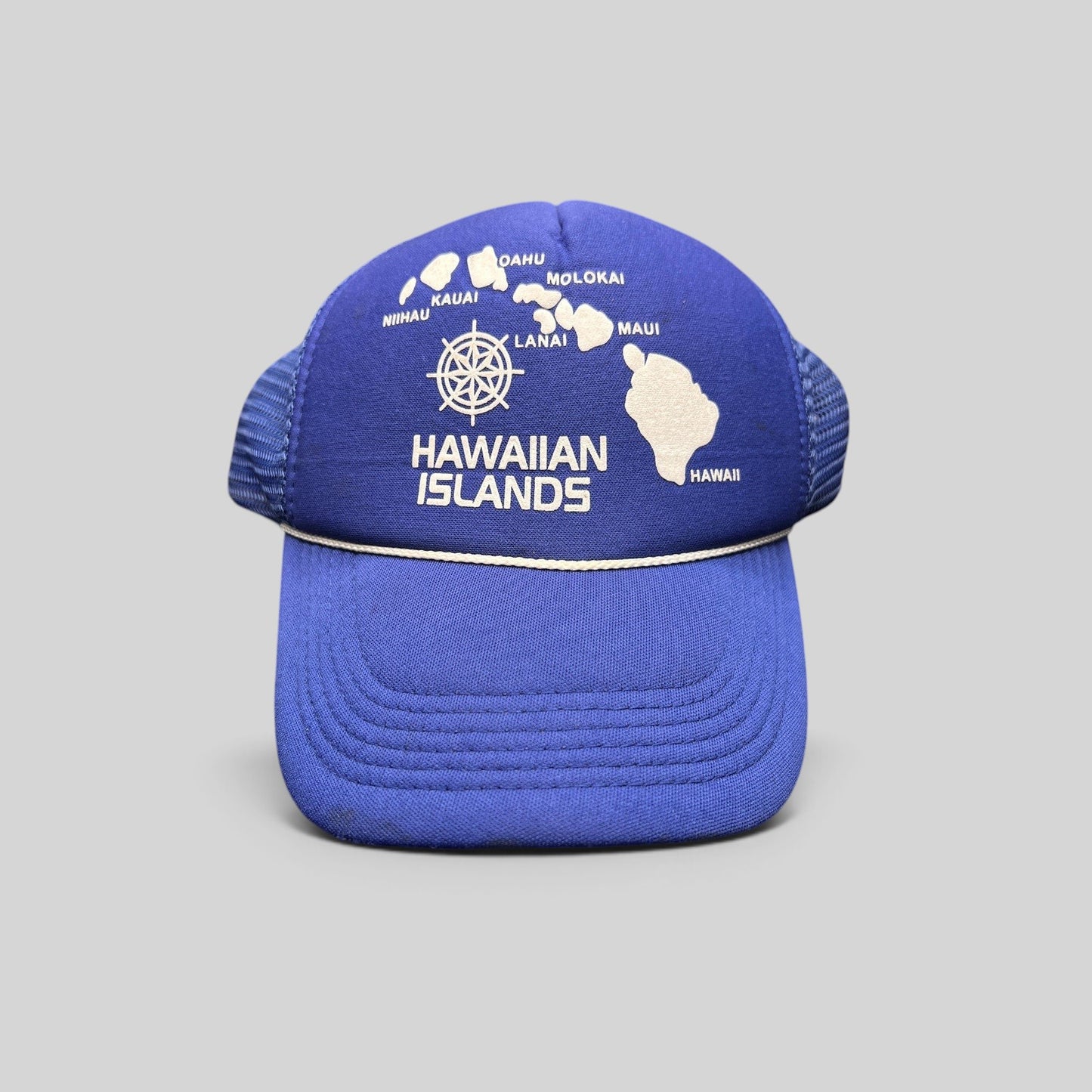 Raree Finds vintage royal blue foam trucker hat with a white Hawaiian Islands map graphic and nautical helm emblem.