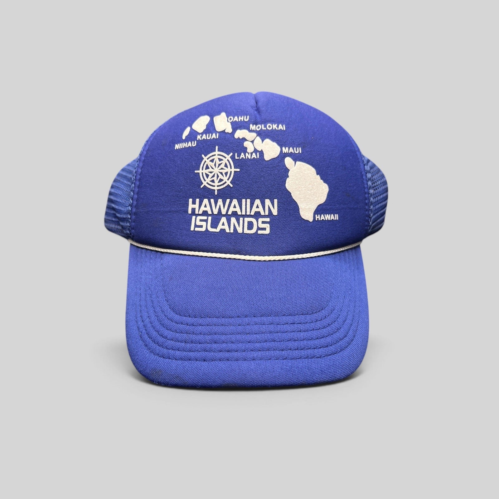 Raree Finds vintage royal blue foam trucker hat with a white Hawaiian Islands map graphic and nautical helm emblem.