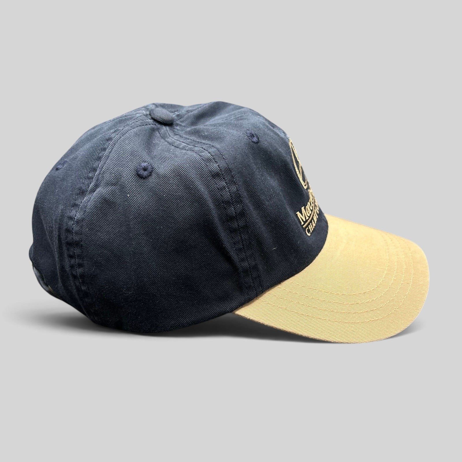 Raree Finds vintage Mercedes-Benz Championship golf hat with navy cotton crown and tan brim, side profile view.