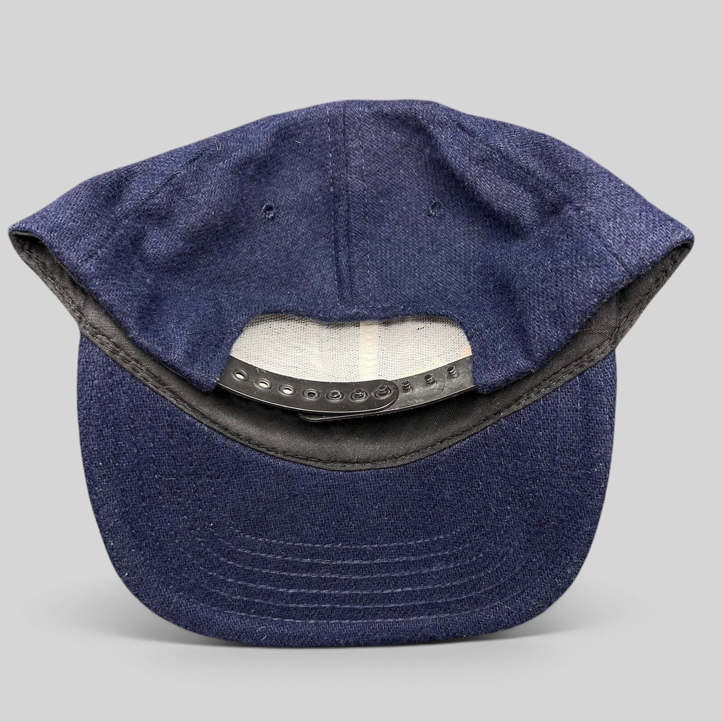Raree Finds vintage 90s No Fear Gear navy wool-blend snapback hat showing the adjustable black plastic back closure
