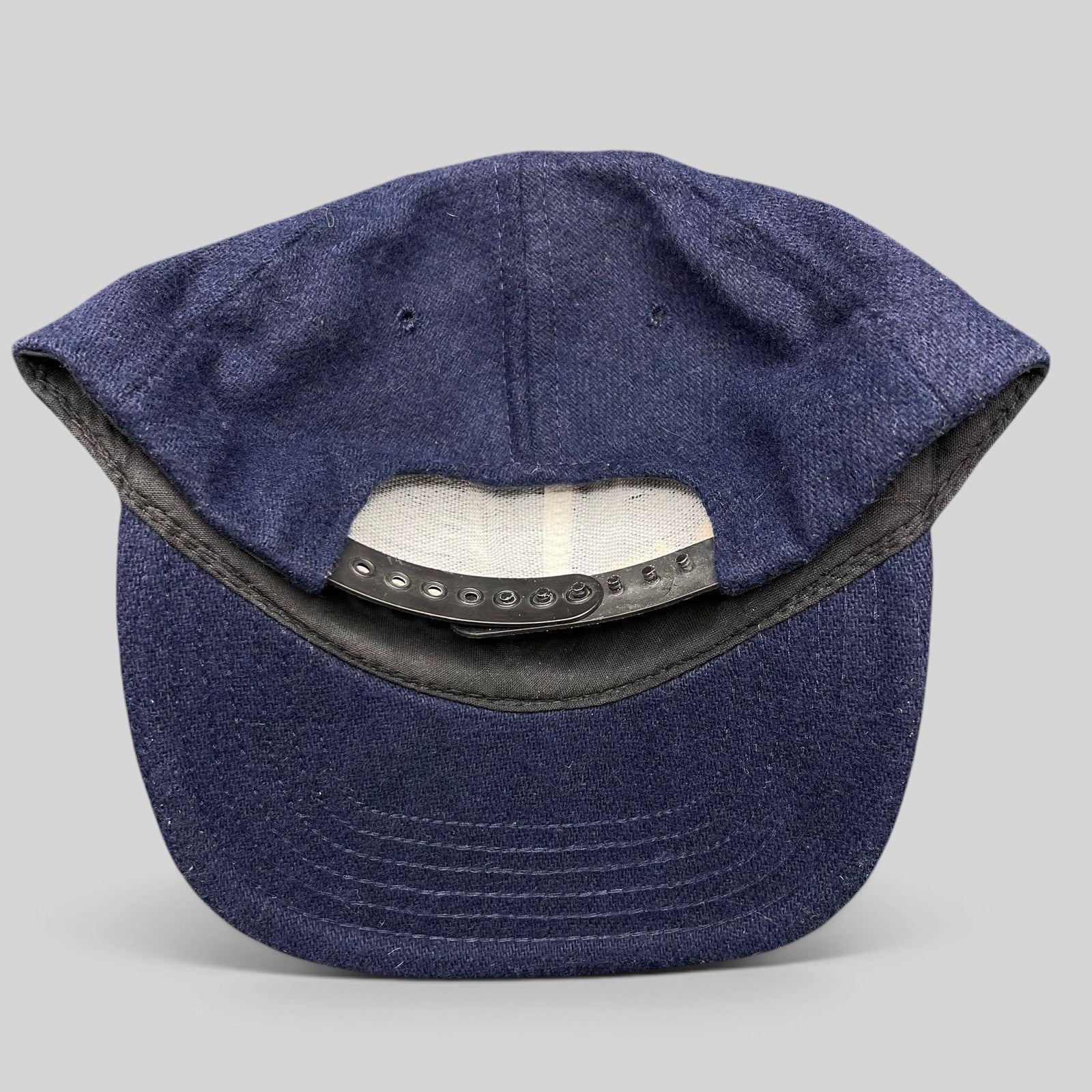 Raree Finds vintage 90s No Fear Gear navy wool-blend snapback hat showing the adjustable black plastic back closure