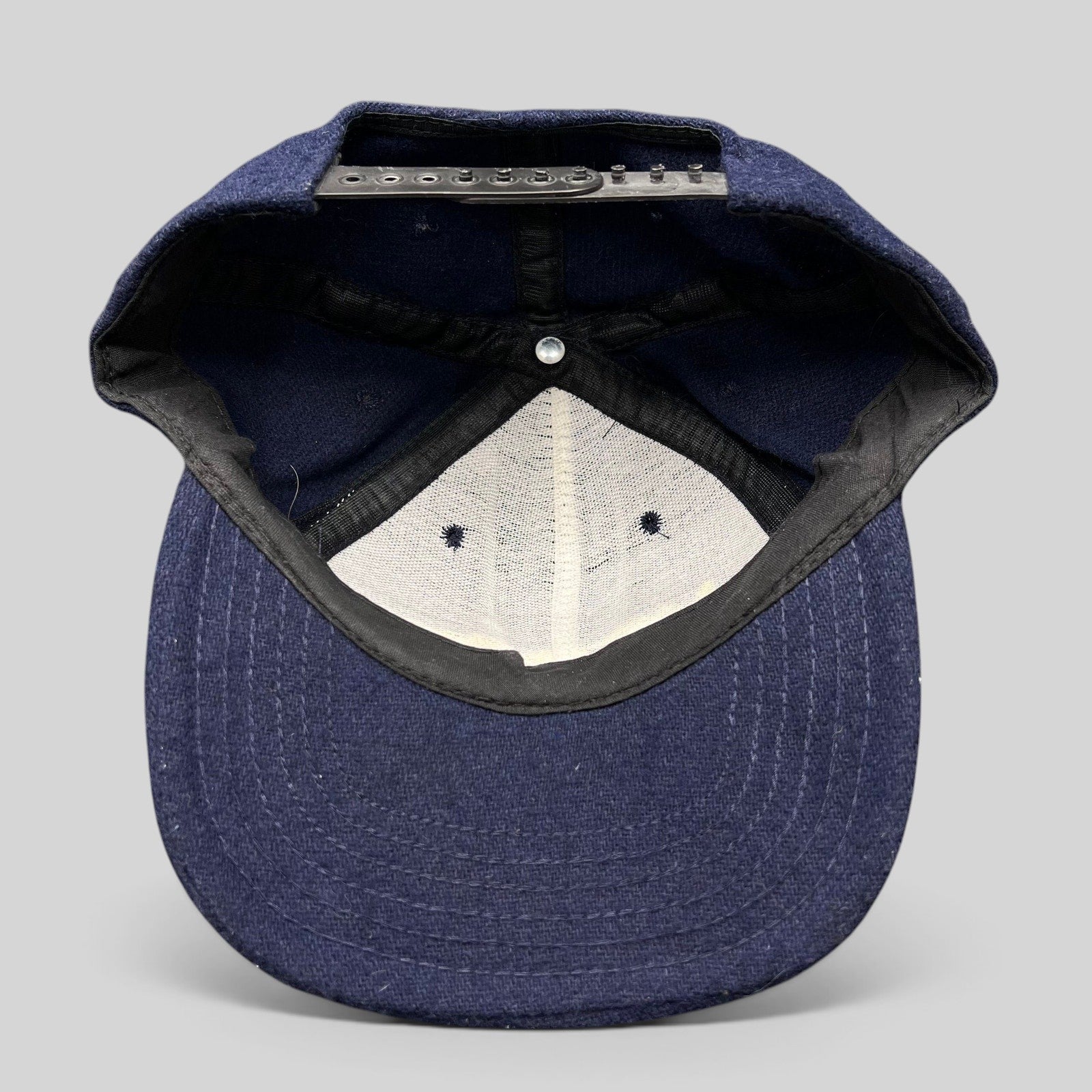 Raree Finds vintage 90s No Fear Gear navy wool snapback hat interior view showing adjustable black plastic strap