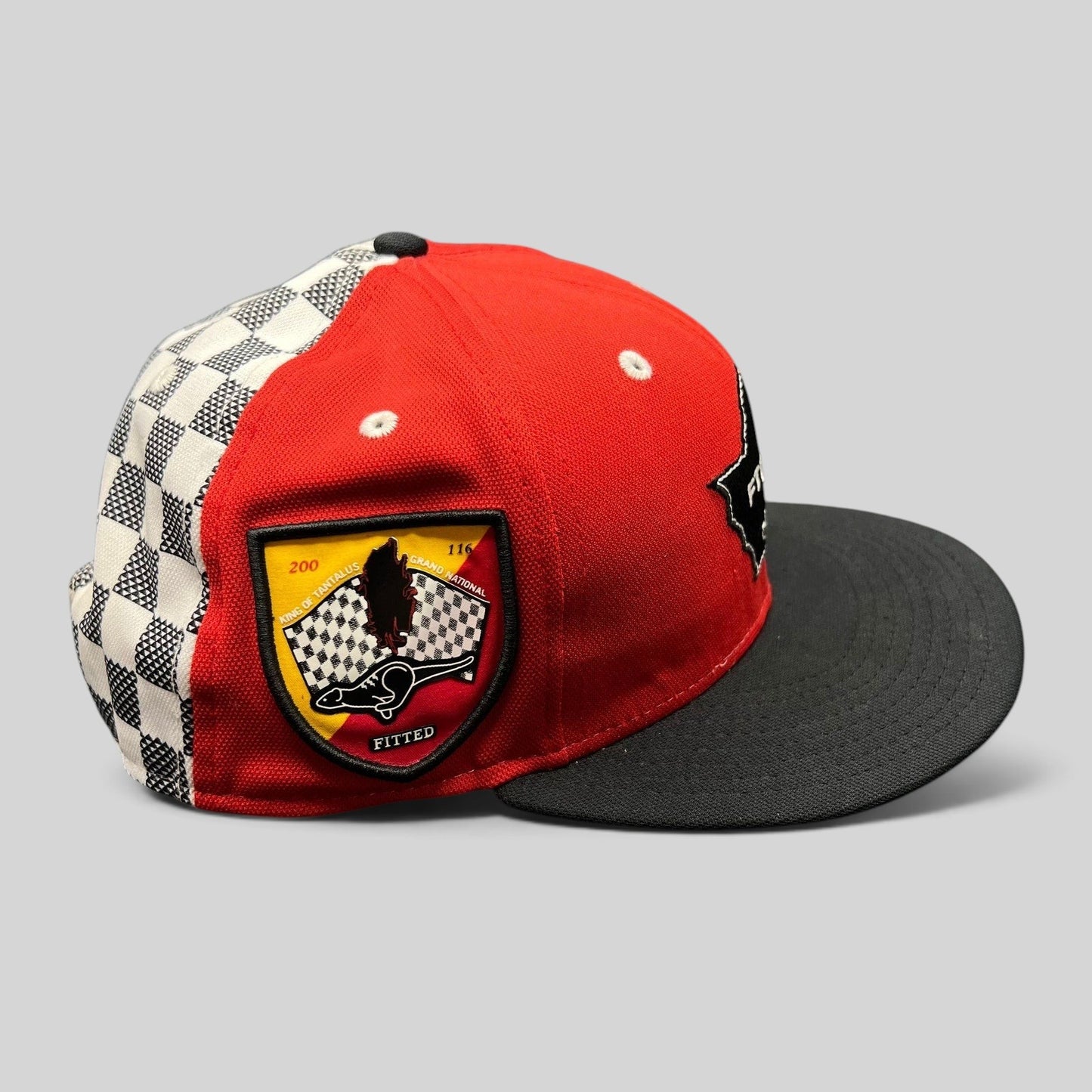 Raree Finds New Era King of Tantalus snapback hat in red and black with a checkered side panel and event patch.