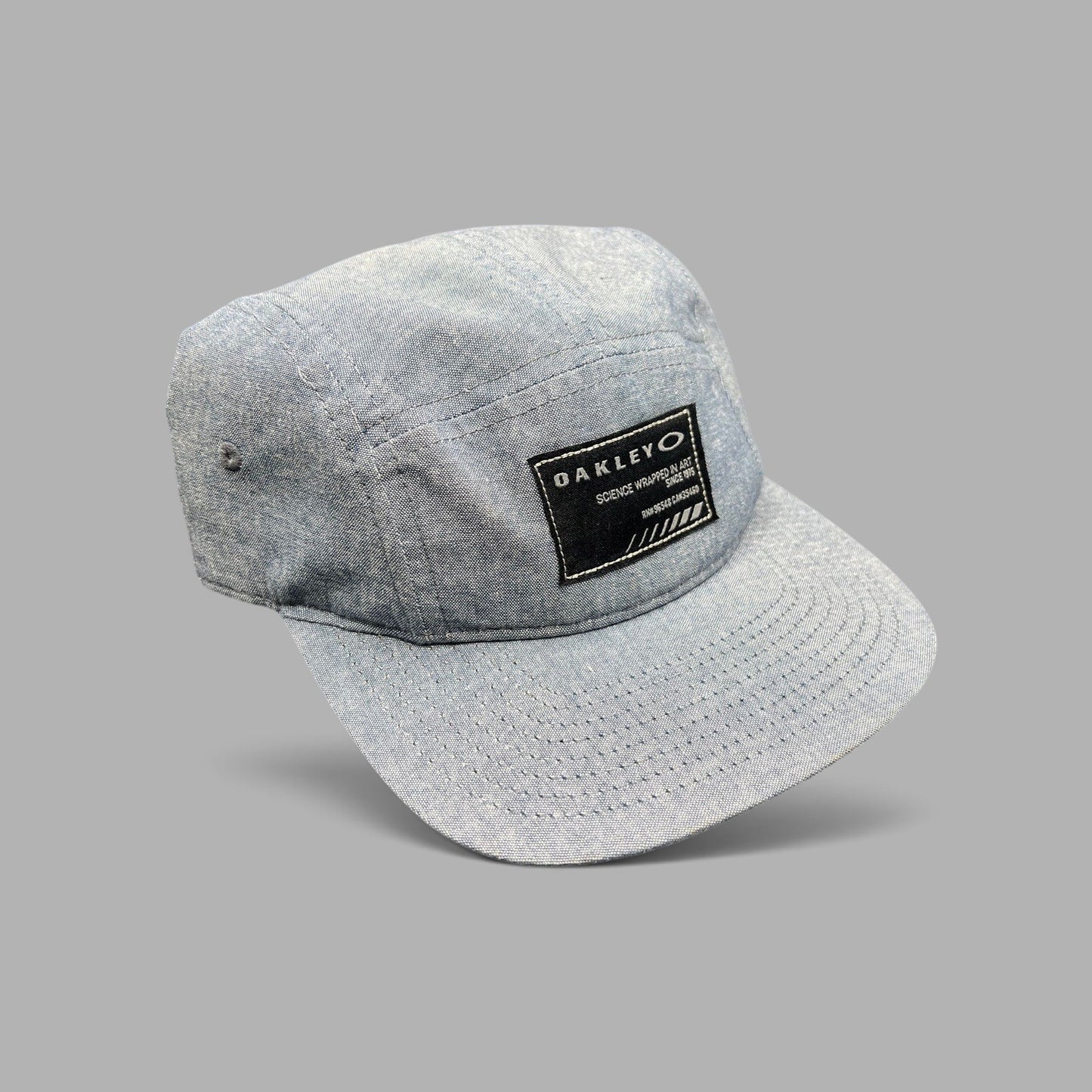 Raree Finds Oakley 5-panel camp cap in light denim chambray with a black Science Wrapped in Art front patch