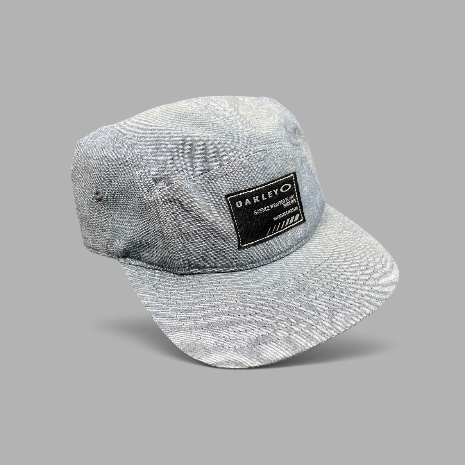 Raree Finds Oakley 5-panel camp cap in light denim chambray with a black Science Wrapped in Art front patch