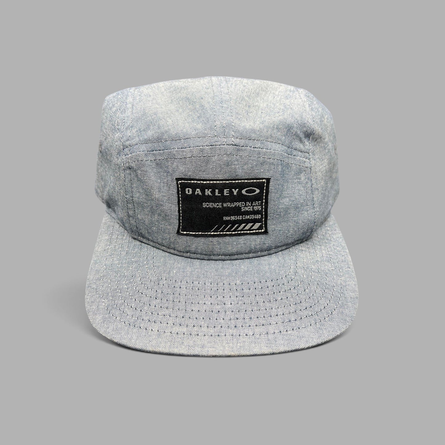 Raree Finds Oakley 5-panel camp cap in light denim chambray with a black Science Wrapped in Art front patch