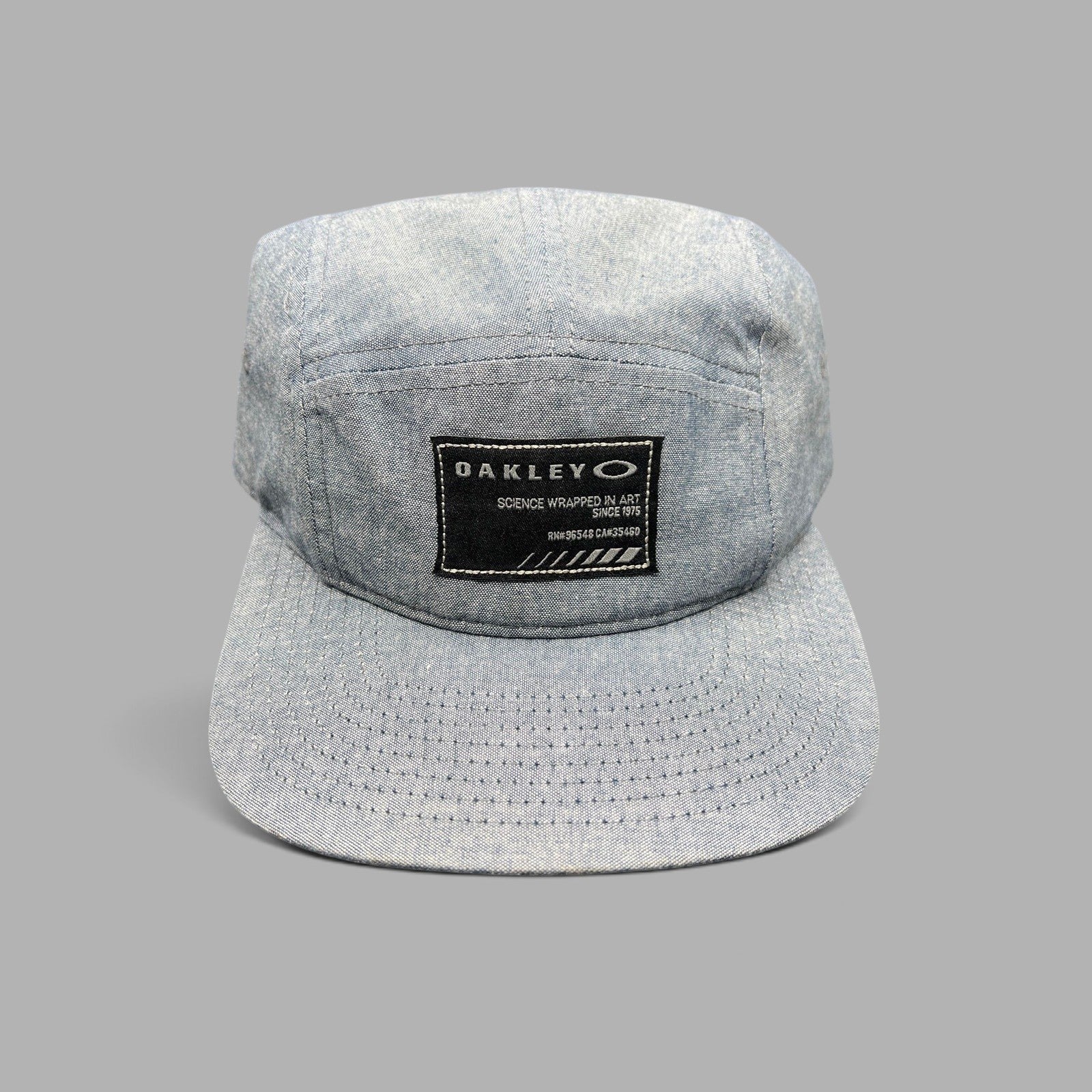 Raree Finds Oakley 5-panel camp cap in light denim chambray with a black Science Wrapped in Art front patch