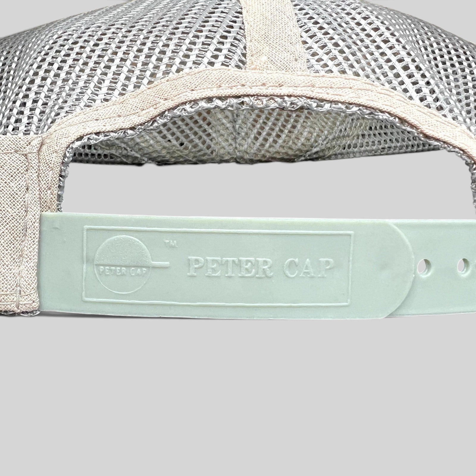 Raree Finds vintage Peter Cap trucker hat snapback closure detail with white mesh and embossed plastic strap