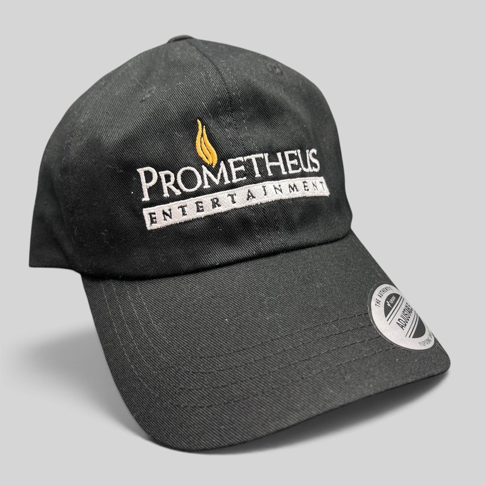 Raree Finds black Yupoong strapback hat with white and orange Prometheus Entertainment logo embroidery