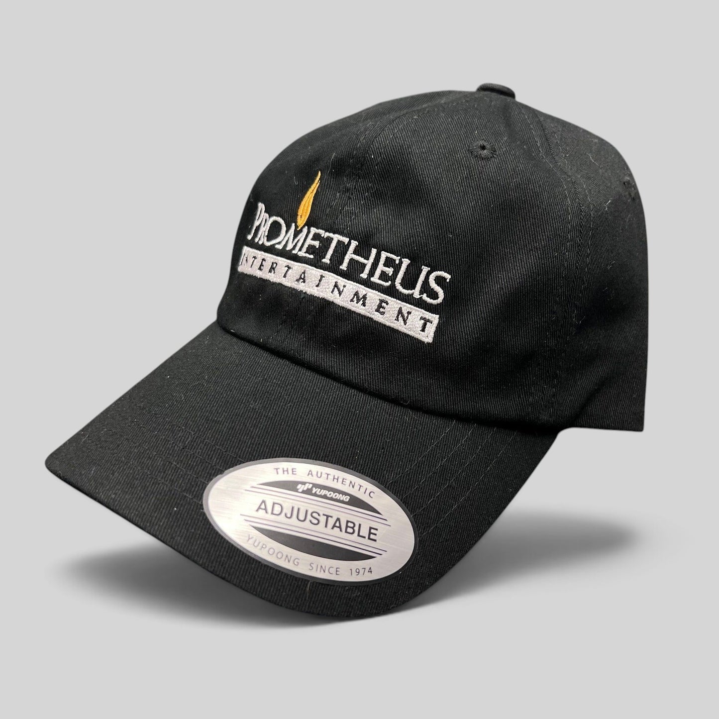 Raree Finds black Yupoong strapback hat with white and orange Prometheus Entertainment logo embroidery