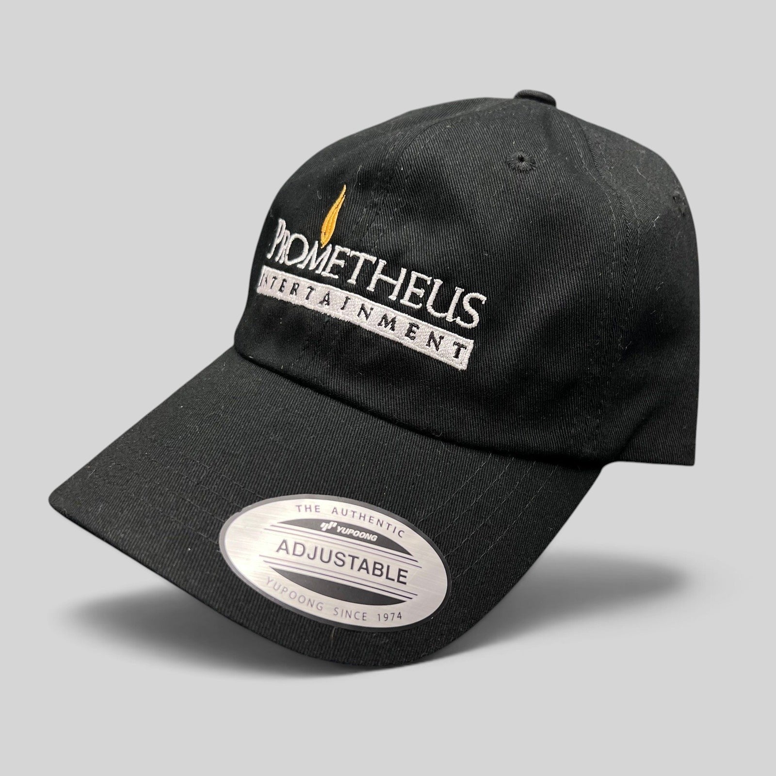 Raree Finds black Yupoong strapback hat with white and orange Prometheus Entertainment logo embroidery