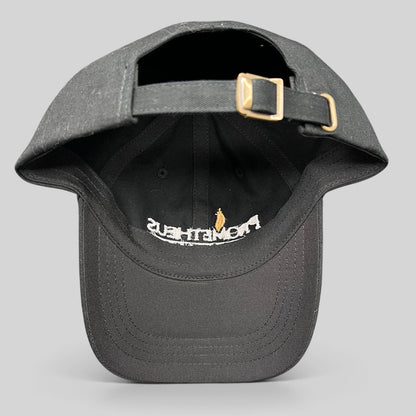 Raree Finds black Yupoong strapback hat with adjustable brass buckle, showing interior embroidery of Prometheus logo.
