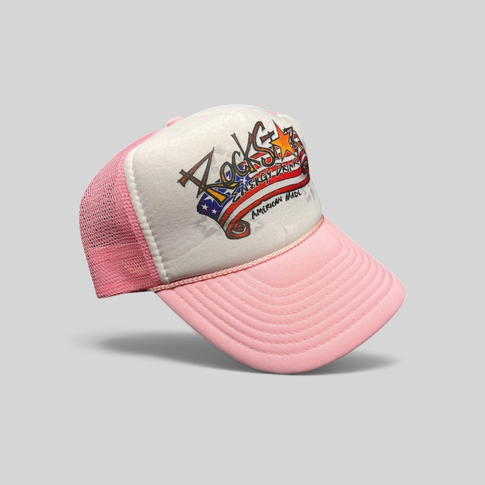 Raree Finds vintage Rockstar Energy Drink trucker hat with white foam front, pink mesh back, and American flag logo.