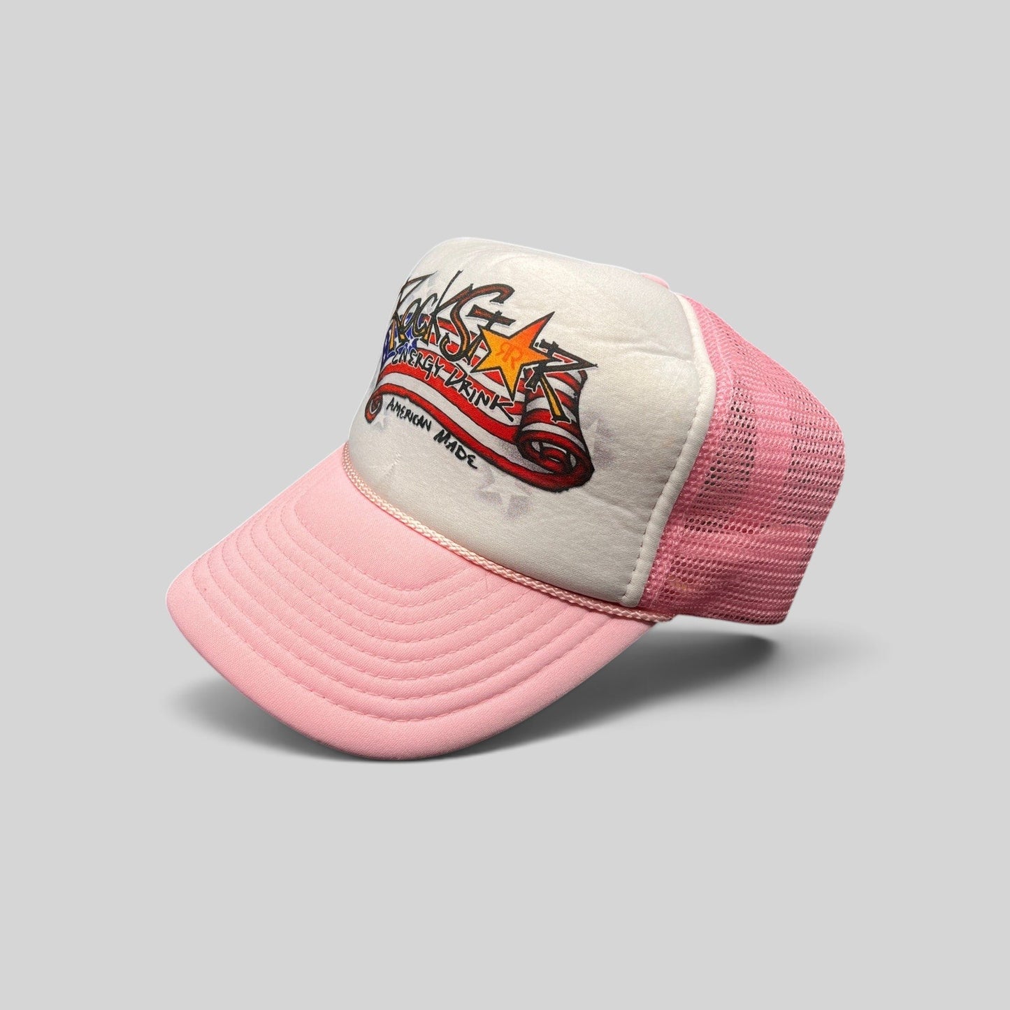 Raree Finds vintage Rockstar Energy Drink trucker hat with white foam front, pink mesh back, and American flag logo.