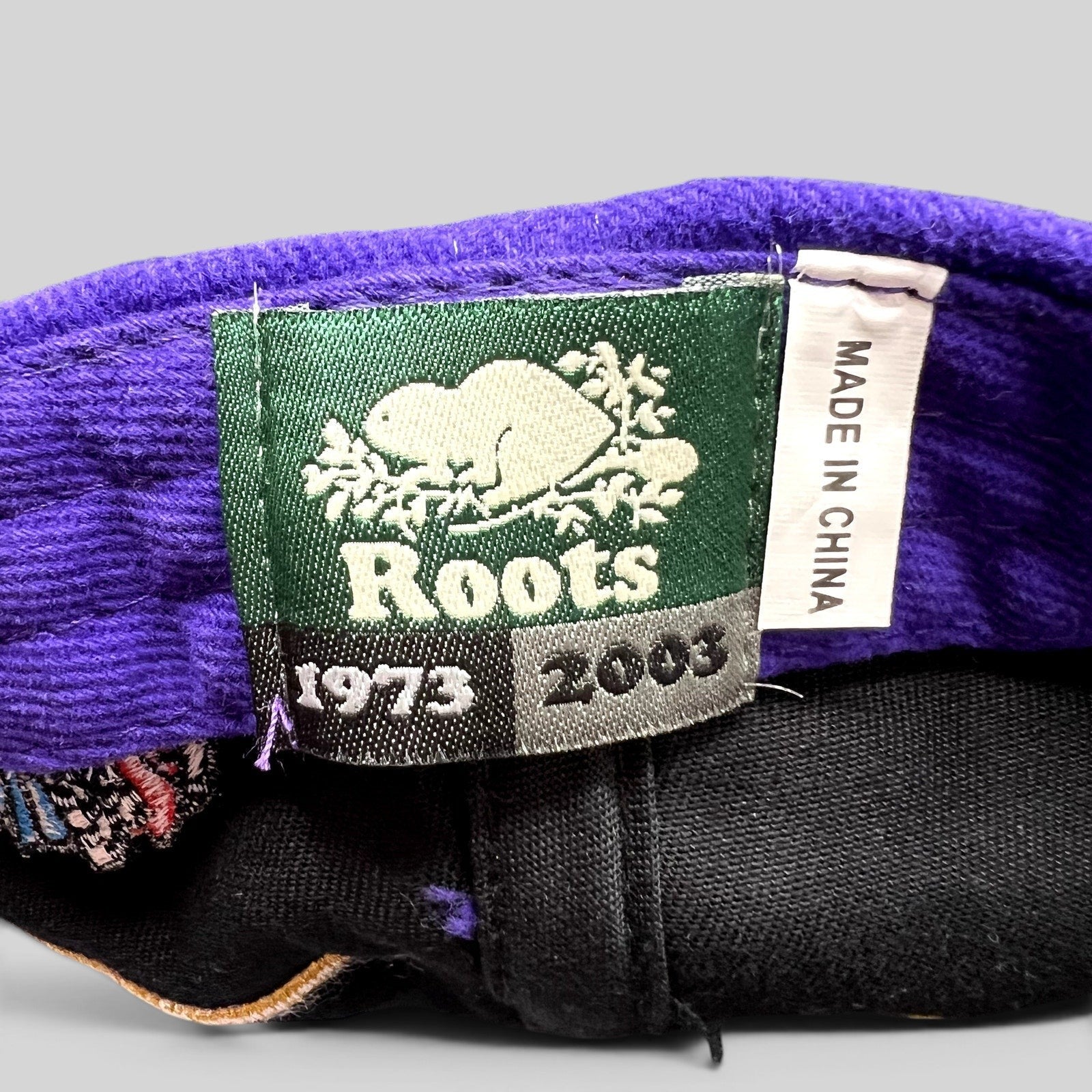 Raree Finds vintage 2003 Roots brand label inside a purple and black Crown Royal promotional hat