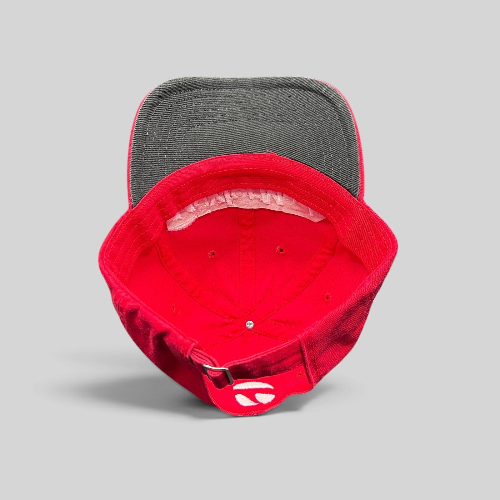 Raree Finds TaylorMade red cotton golf cap with black brim, showing the interior construction and adjustable strapback.