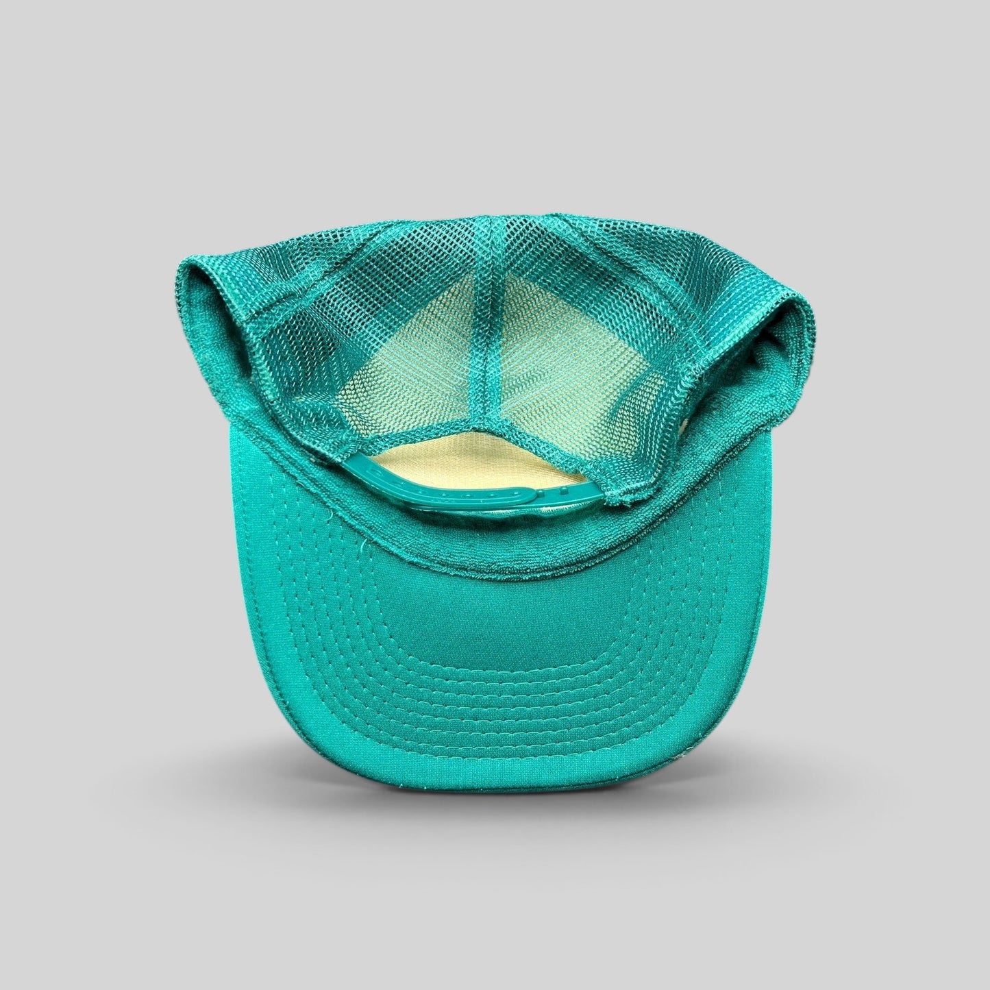 Raree Finds teal mesh trucker hat with adjustable snapback closure, showing the interior and breathable mesh back.