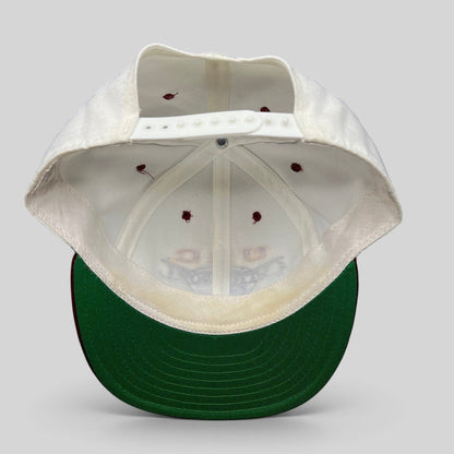 Raree Finds vintage 1995 USC Cotton Bowl snapback hat showing the white interior, plastic snap closure, and green brim.