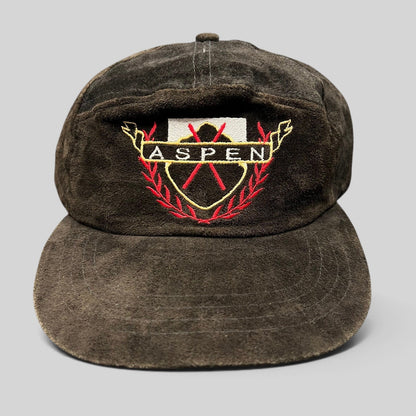 Raree Finds vintage black suede Aspen strapback hat with embroidered crest logo and gold, red, and white accents.