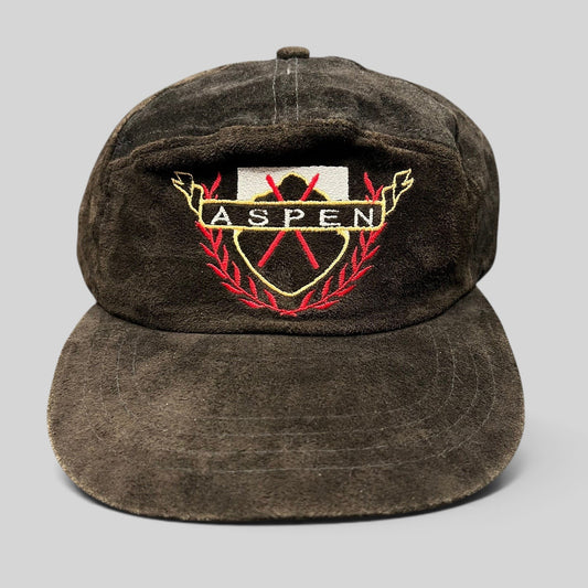 Raree Finds vintage black suede Aspen strapback hat with embroidered crest logo and gold, red, and white accents.