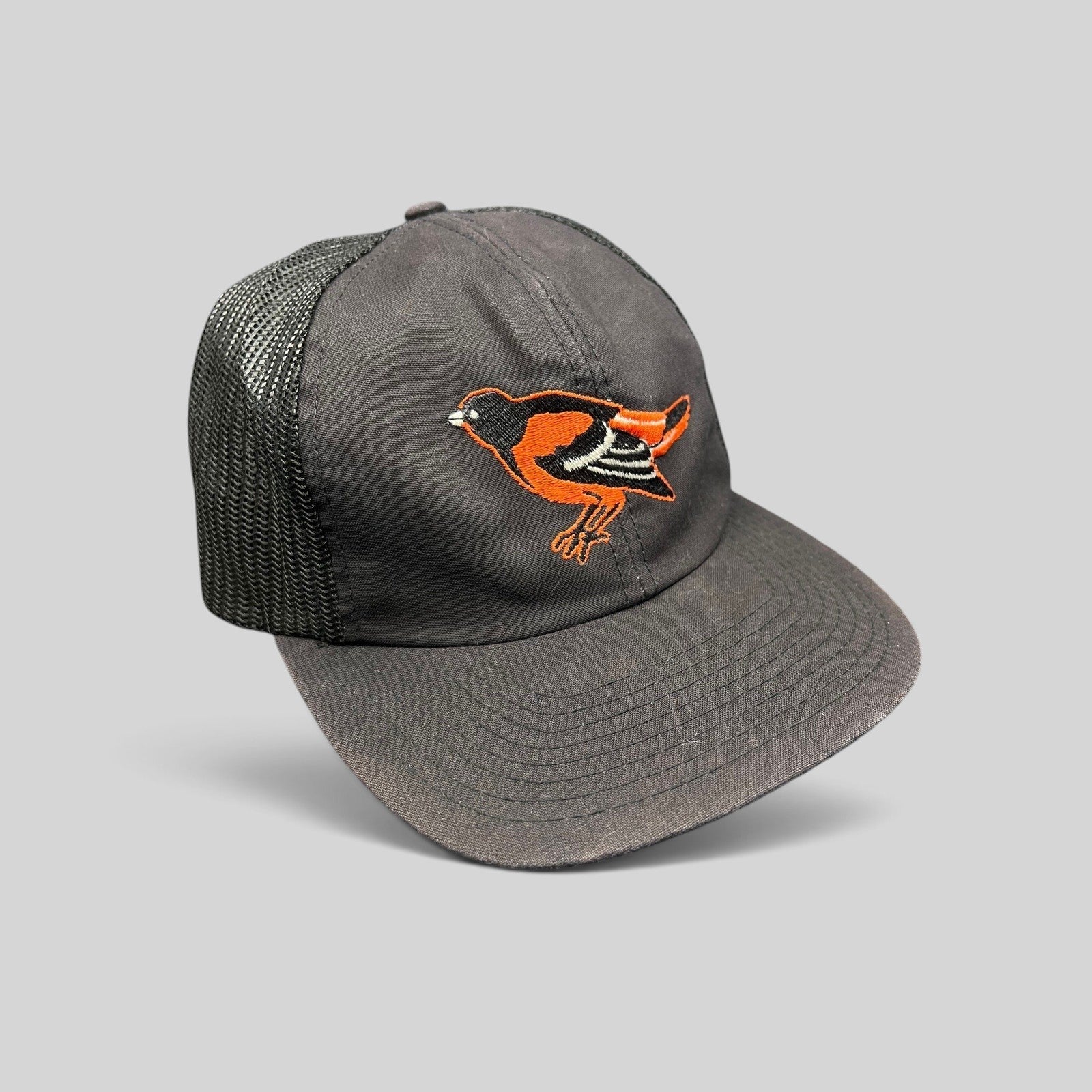 Raree Finds vintage 1980s Baltimore Orioles black mesh snapback hat with embroidered orange bird logo and green brim.