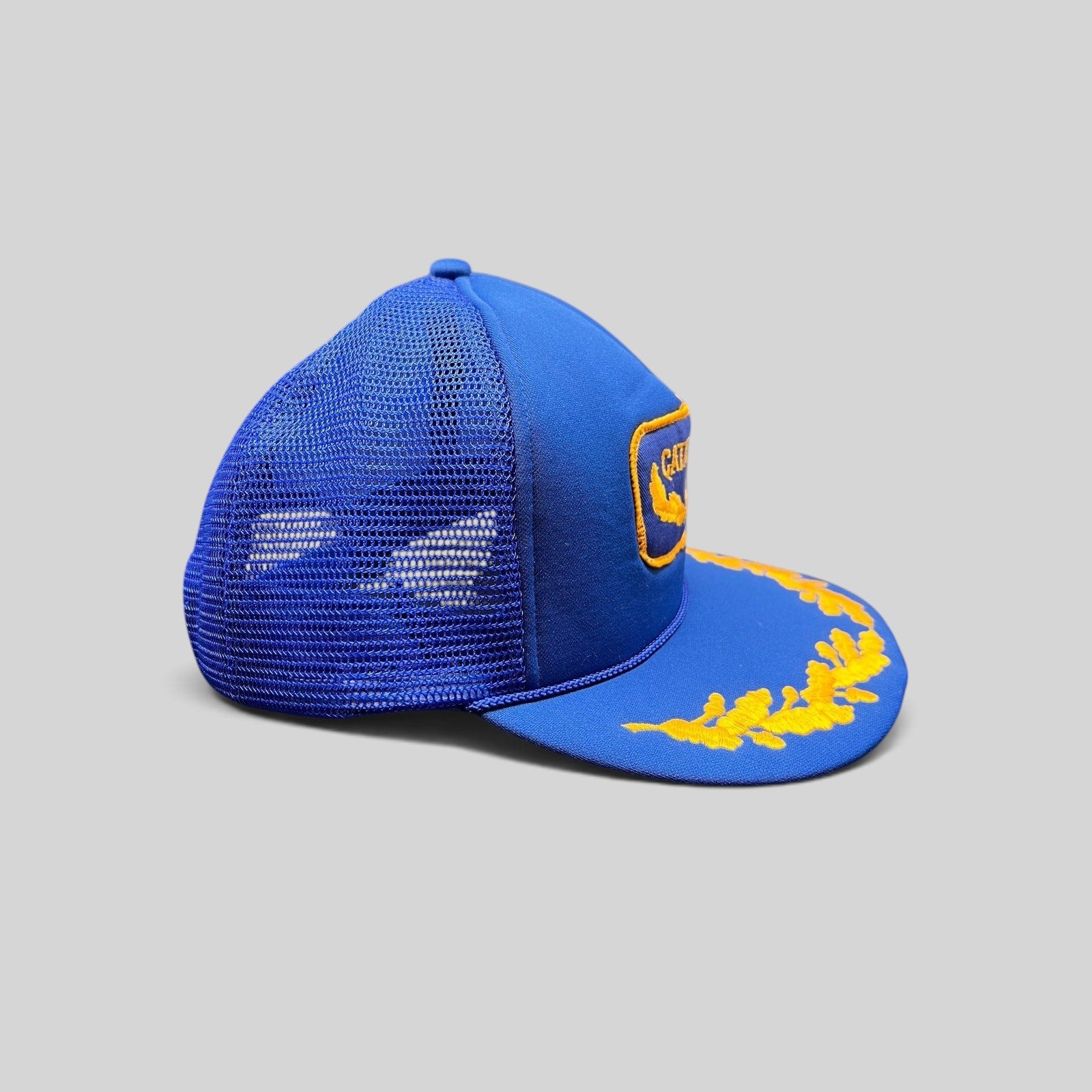 Raree Finds vintage 1980s royal blue trucker hat with gold embroidered laurel leaves on the brim and mesh back