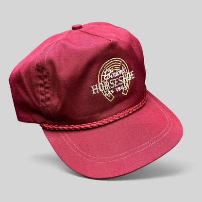 Raree Finds vintage burgundy cotton strapback hat with Binion’s Horseshoe Las Vegas embroidered logo and rope detail.