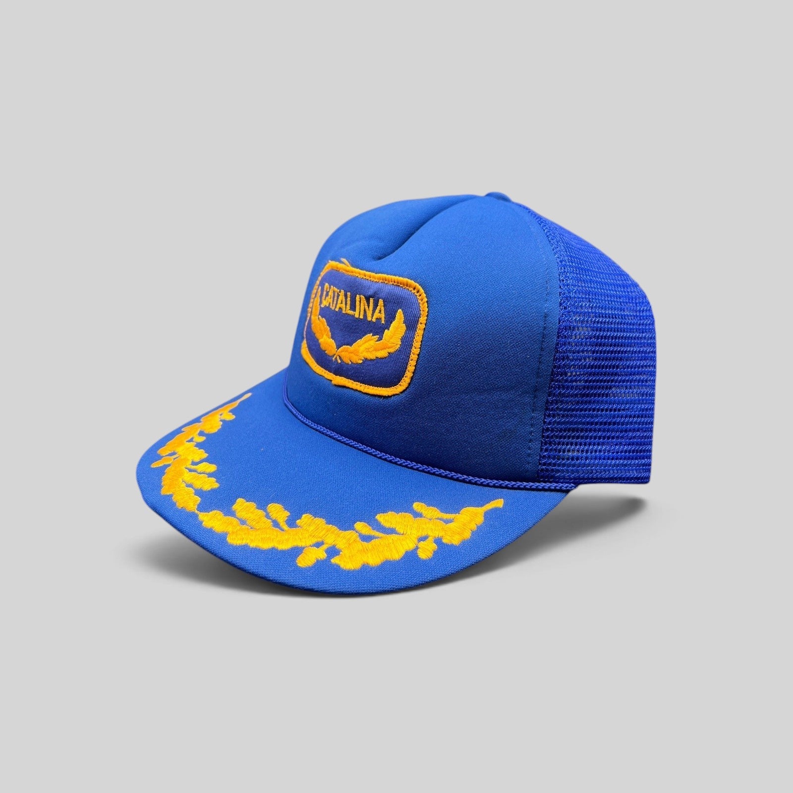 Raree Finds vintage 1980s royal blue trucker hat with gold embroidered Catalina patch and laurel brim detail