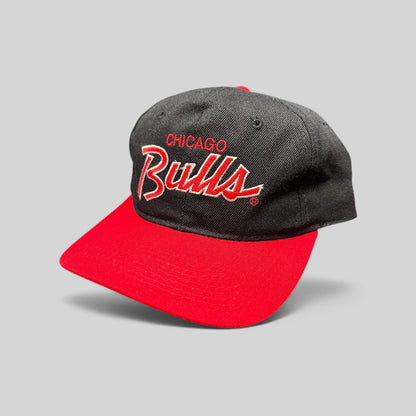 Raree Finds vintage 90s Chicago Bulls snapback hat with red and white script embroidery on a black crown and red brim.