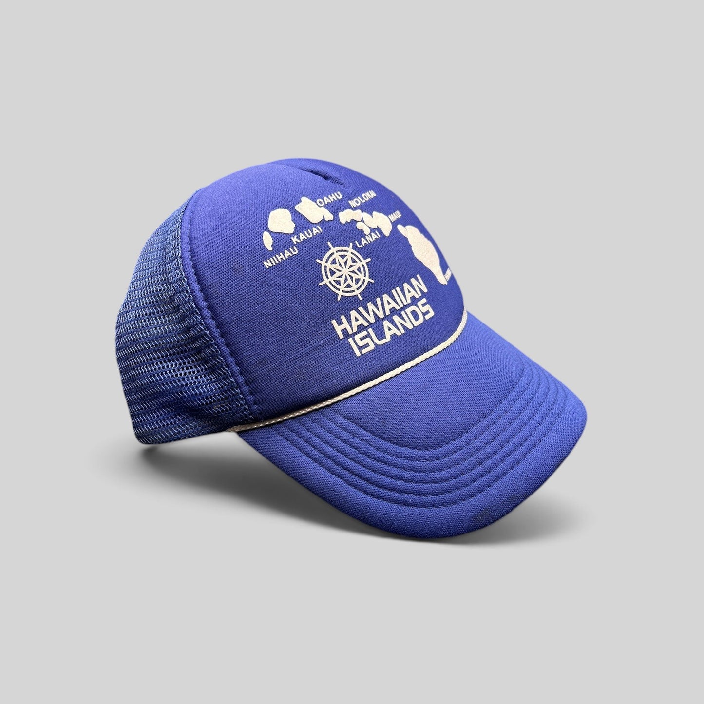 Raree Finds vintage royal blue foam trucker hat with a white Hawaiian Islands map graphic and nautical helm emblem.