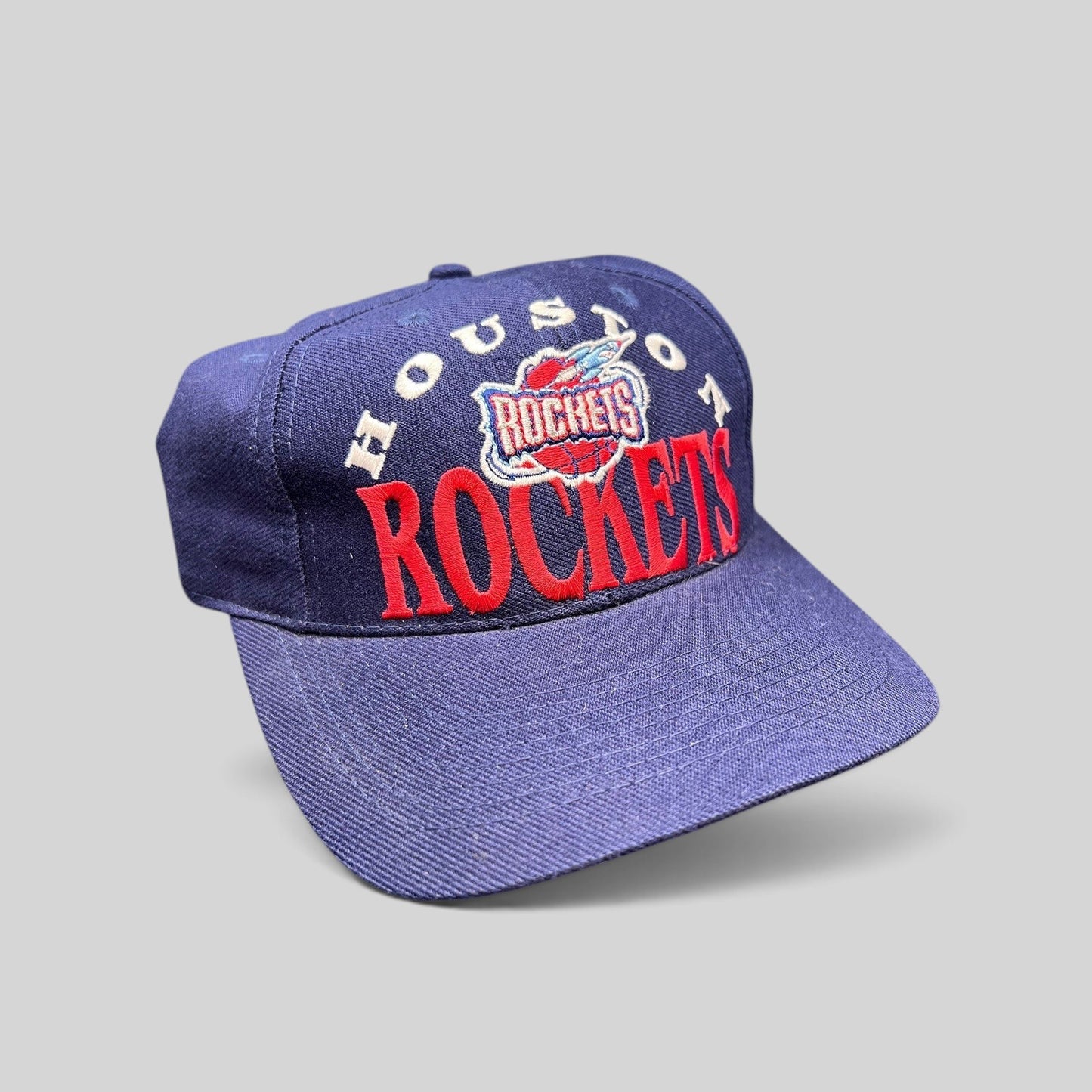 Raree Finds vintage 1990s Houston Rockets snapback hat in navy blue with red embroidered logo and green undervisor