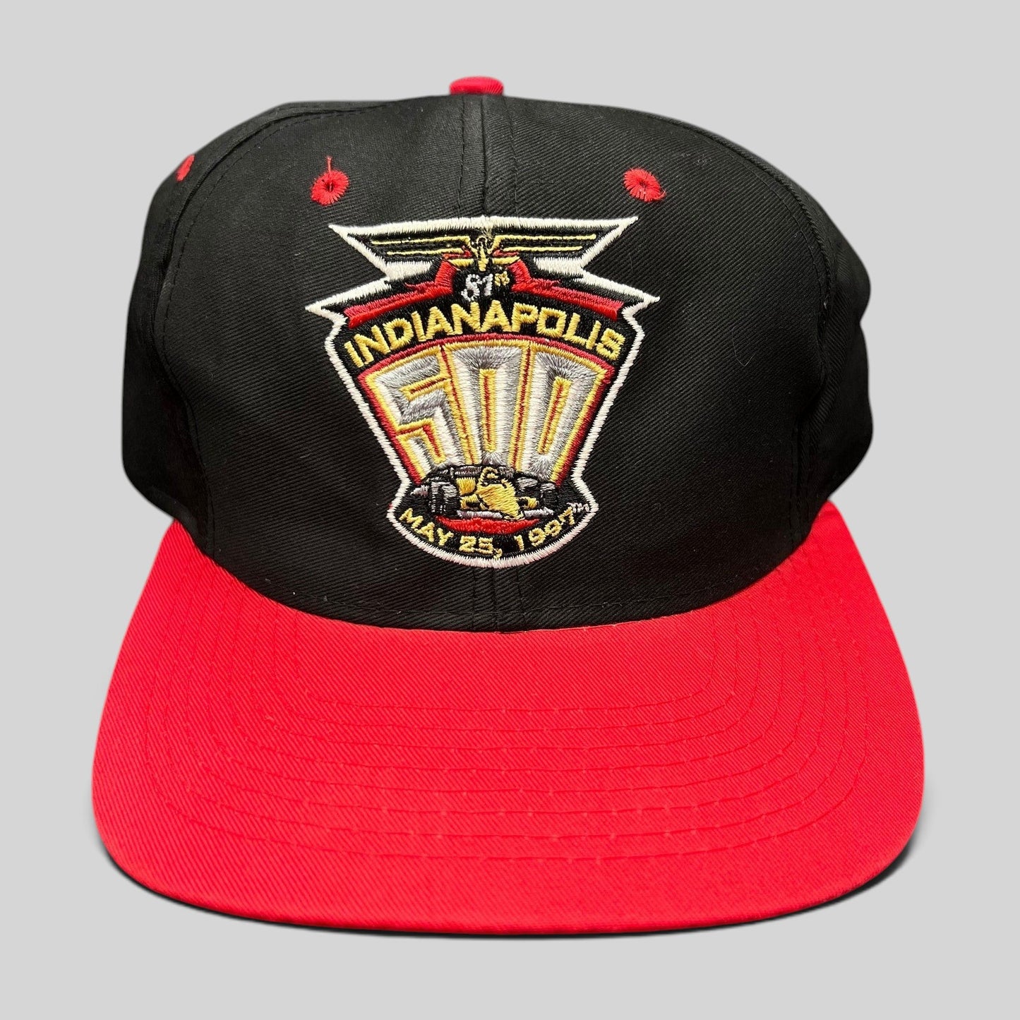 Raree Finds vintage 1997 Indianapolis 500 snapback hat with black crown, red brim, and embroidered racing logo.